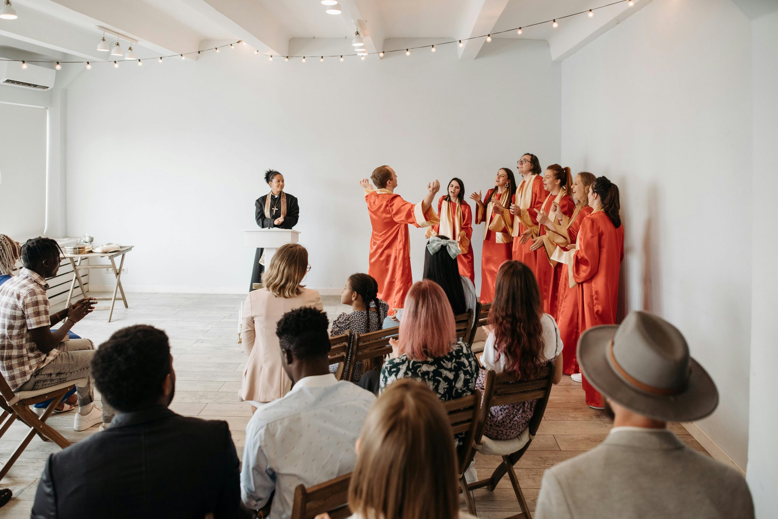 A choir in red robes performs during a church service, engaging the audience.